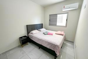 um pequeno quarto com uma cama e uma janela em 103 - Apartamento Completo Para Até 5 Hóspedes em Patos de Minas