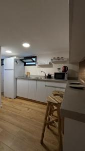 a kitchen with white cabinets and a white refrigerator at דירת סטודיו באווירת צימר במתחם נגה,דקה הליכה מהים. in Tel Aviv