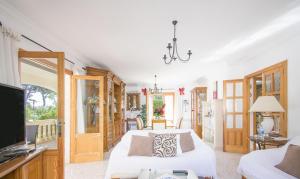 a bedroom with a white bed and a television at Playas de Mallorca in Muro