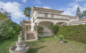 a large white house with a garden in front of it at Playas de Mallorca in Muro