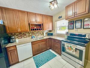 a kitchen with wooden cabinets and a stove top oven at Saltwater Retreat of Redington Shores in St Pete Beach