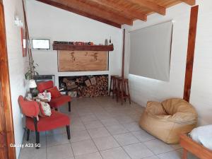 sala de estar con sillas rojas y chimenea en Antares en Villa La Angostura