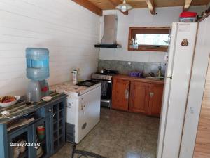 a kitchen with a stove and a white refrigerator at Antares in Villa La Angostura