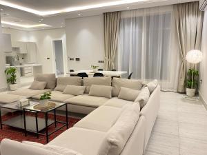 الرياض البوليفارد شقق عبيه Vip الفاخره في الرياض: غرفة معيشة مع أريكة بيضاء وطاولة