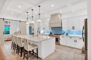 a kitchen with white cabinets and a large kitchen island at SOUTHERN SEABREEZE 5BR POOL & BEACH by Barclé in Rosemary Beach