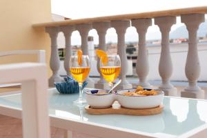 twee glazen wijn en een kom eten op een tafel bij Casa Duesse in Orosei