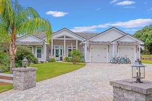 a house with a palm tree and a driveway at SOUTHERN SEABREEZE 5BR POOL & BEACH by Barclé in Rosemary Beach