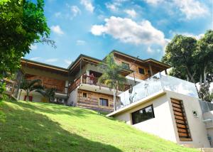 a house on top of a grassy hill at Villa Flor in Jarabacoa