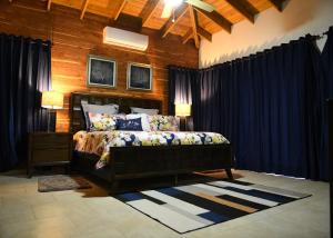 a bedroom with a bed with blue curtains at Villa Flor in Jarabacoa