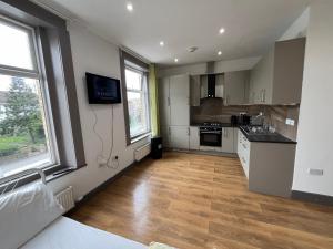 una cucina con pareti bianche e pavimenti e finestre in legno di Anerly Road a Londra