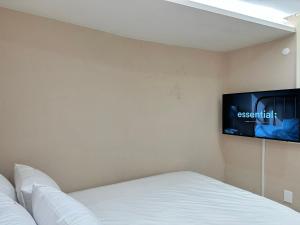 釜山的住宿－Hoho House，卧室配有一张床和壁挂式平面电视。