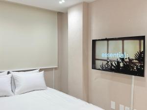 Hoho House في بوسان: غرفة نوم بسرير وتلفزيون على جدار