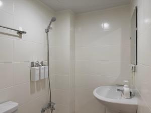 La salle de bains blanche est pourvue d'une douche et d'un lavabo. dans l'établissement Hoho House, à Busan