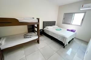 a room with two bunk beds and a window at 104 - Apartamento Completo para até 7 Hóspedes in Patos de Minas
