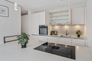 a kitchen with white cabinets and a black appliance at Luxury 2BR, Free Parking, Balcony in Luxembourg +25 photos