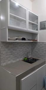 een aanrecht met witte kasten en een wastafel bij 2Ms in Baguio