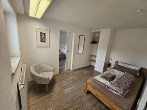 um quarto com uma cama e uma cadeira em Ferienwohnung am Wildpark HDH em Heidenheim an der Brenz