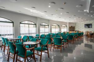Una gran sala con mesas, sillas y ventanas. en A Mariña, en Cambados