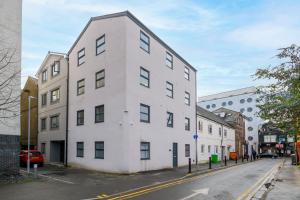 a white building on the side of a street at Benjamin Suite by Koya Homes - 3 Double Bedroom Apartment, Cardiff City Centre, Free Parking in Cardiff