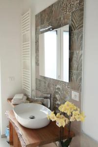 a bathroom with a sink and a mirror and flowers at Cà d'Rita Monferrato - Barbera in Vinchio