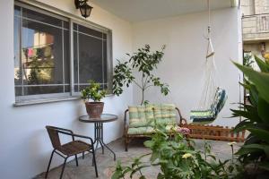 a patio with a chair and a table and a window at Studio 1 in Katerini in Katerini