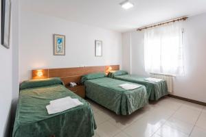 Una habitación de hotel con dos camas y una ventana. en A Mariña, en Cambados 101 fotos más