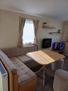 sala de estar con sofá y mesa en Caravan Holiday Home @ Marton Mere, BLACKPOOL, en Blackpool