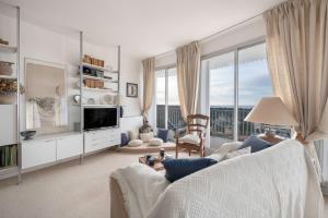 a living room with a white couch and a large window at Superbe balcon - Vue mer - Appart pour 2 in La Baule