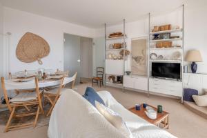 a living room with a table and a couch at Sejour detente et panorama enchanteur in La Baule