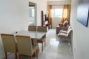 uma sala de estar com uma mesa branca e cadeiras em 202- APARTAMENTO de 2 QUARTOS para até 5 HÓSPEDES em Patos de Minas