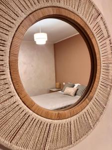 a round mirror with a bed in a bedroom at Mirabel in Chieti