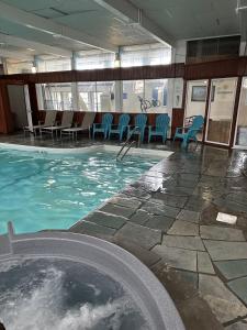 a swimming pool with chairs in a building at Trade Winds on the Bay in Rockland