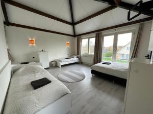 a bedroom with two beds and a large window at Groot vakantiehuis nabij Amsterdam inclusief jacuzzi in Zeewolde +19 photos