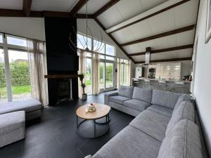 ein Wohnzimmer mit einem Sofa und einem Tisch in der Unterkunft Groot vakantiehuis nabij Amsterdam inclusief jacuzzi in Zeewolde
