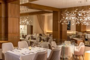 a dining room with white tables and chairs at Le Blanc Spa Resort Cancun Adults Only All-Inclusive in Cancún