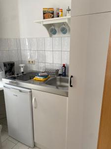 uma cozinha com um lavatório e uma bancada em Strandkojen em Trassenheide