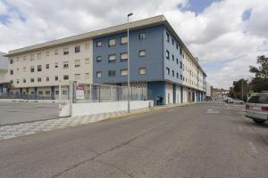 an empty street in front of a large building at Apartamento EL MIRADOR, recepción 24 h, piscina, wifi y parking interior in Bormujos