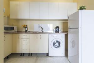a kitchen with a washing machine and a refrigerator at Apartamento EL MIRADOR, recepción 24 h, piscina, wifi y parking interior in Bormujos