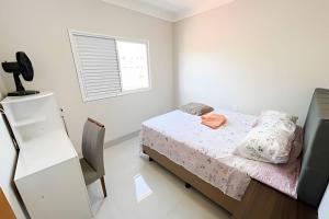 um pequeno quarto com uma cama e uma janela em M203- Apartamento c/ Suíte Completo Patos de Minas em Patos de Minas