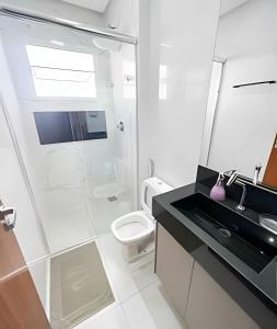 a bathroom with a shower and a sink and a toilet at M203- Apartamento c/ Suíte Completo Patos de Minas in Patos de Minas