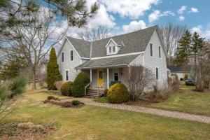 una casa blanca con techo gris en Green Leaves - Family Getaway in PEC, en Bloomfield