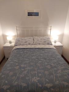 een slaapkamer met een groot bed met 2 nachtkastjes bij 2 bed barn with spectacular views - Wye Valley in Symonds Yat