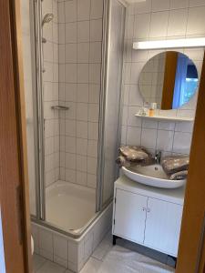 uma casa de banho com um chuveiro e um lavatório. em Strandkojen em Trassenheide
