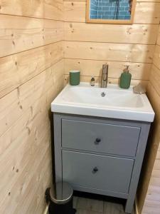 a bathroom with a white sink in a wooden wall at Welcoming new architects house with jacuzzi in Hourtin