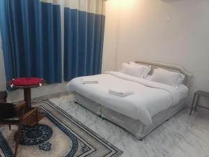 ein Schlafzimmer mit einem weißen Bett mit einem blauen Vorhang in der Unterkunft Jabal Shams bayt kawakib in Misfāh