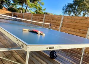 a ping pong table sitting on top of a deck at Welcoming new architects house with jacuzzi in Hourtin