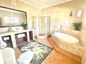 a bathroom with a tub and a toilet and a sink at Franschhoek Mountain Escape in Franschhoek