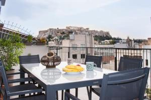 Breathtaking Acropolis Penthouse Ultimate Comfort في أثينا: طاولة مع الموز على رأس شرفة