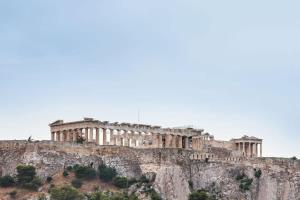 Breathtaking Acropolis Penthouse Ultimate Comfort في أثينا: مبنى جالس فوق جبل