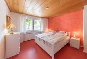 a bedroom with a white bed and a window at Unter den Reben in Niederkirchen bei Deidesheim